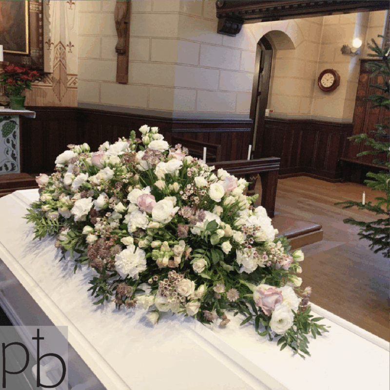 Erfaren begravelsesflorist binder klassisk bårebuket i hvide nuancer