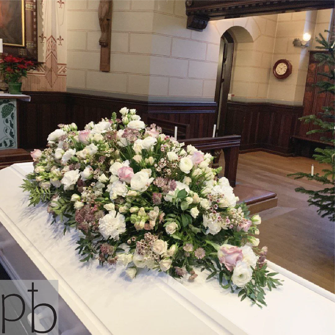 Erfaren begravelsesflorist binder klassisk bårebuket i hvide nuancer