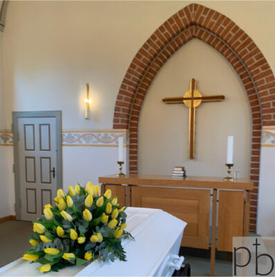 Håndbundet bårebuket og krans til begravelse i Birkerød med roser og liljer