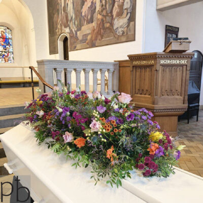 Håndbundet bårebuket med hvide roser og grønne detaljer, leveret af lokal florist i Brønshøj til en smuk og respektfuld afsked.