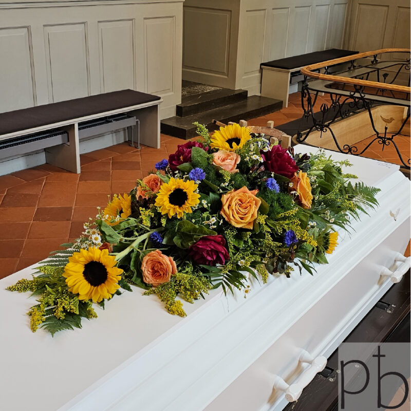 Håndbundne bårebuketter og sorgkranse bundet med liljer og roser, klar til ceremonier i Farum postnummer 3520