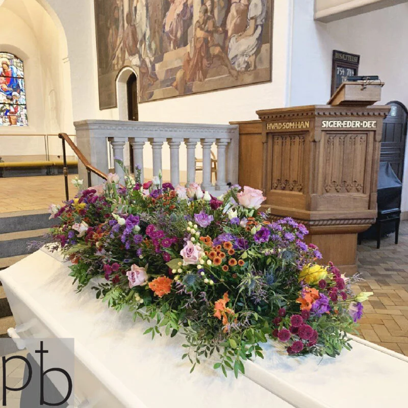 Erfaren florist til begravelsesblomster i Valby binder håndbundne bårebuketter og kranse med silkebånd og personlig tekst