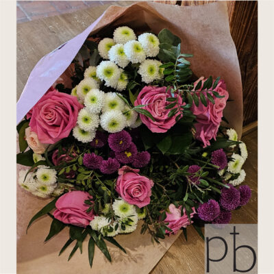 Håndbundet kondolencebuket med hvide liljer, roser og pastelfarvede blomster leveret diskret i Farum postnummer 3520