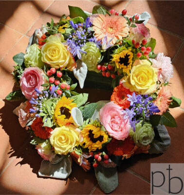 Smuk sorgbuket med hvide liljer og roser til begravelse i Hørsholm leveret af ParadisBlomster.dk