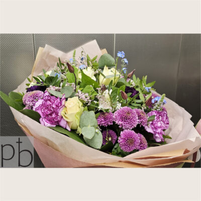 Elegant kondolencebuket med hvide liljer og grønne blade leveret i Hørsholm af ParadisBlomster.dk