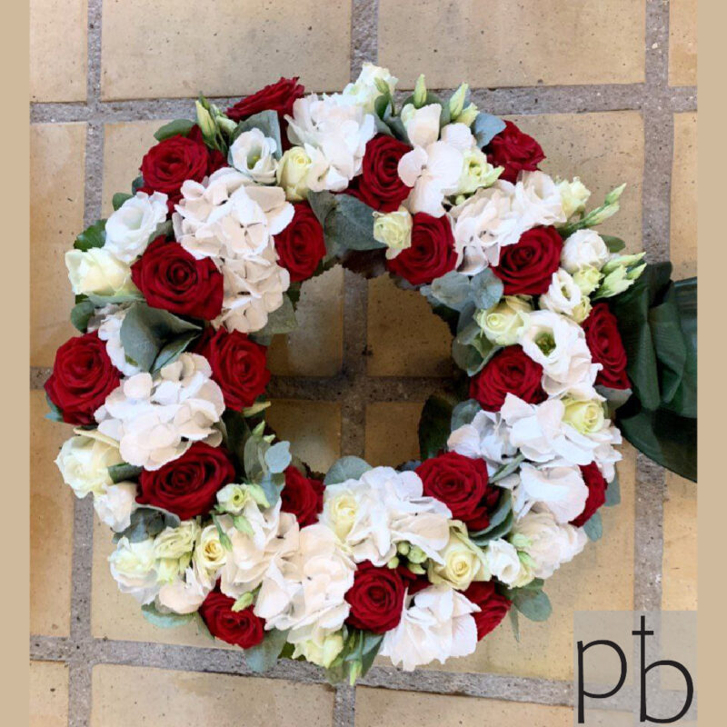 Begravelseskrans i hvid og grøn med rolig, klassisk ringform, leveret planlagt og respektfuldt