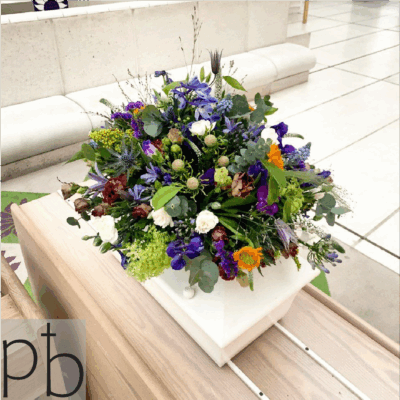 Begravelsesblomster i hvid og grøn med rolig komposition, leveret planlagt og respektfuldt til kirke eller kapel