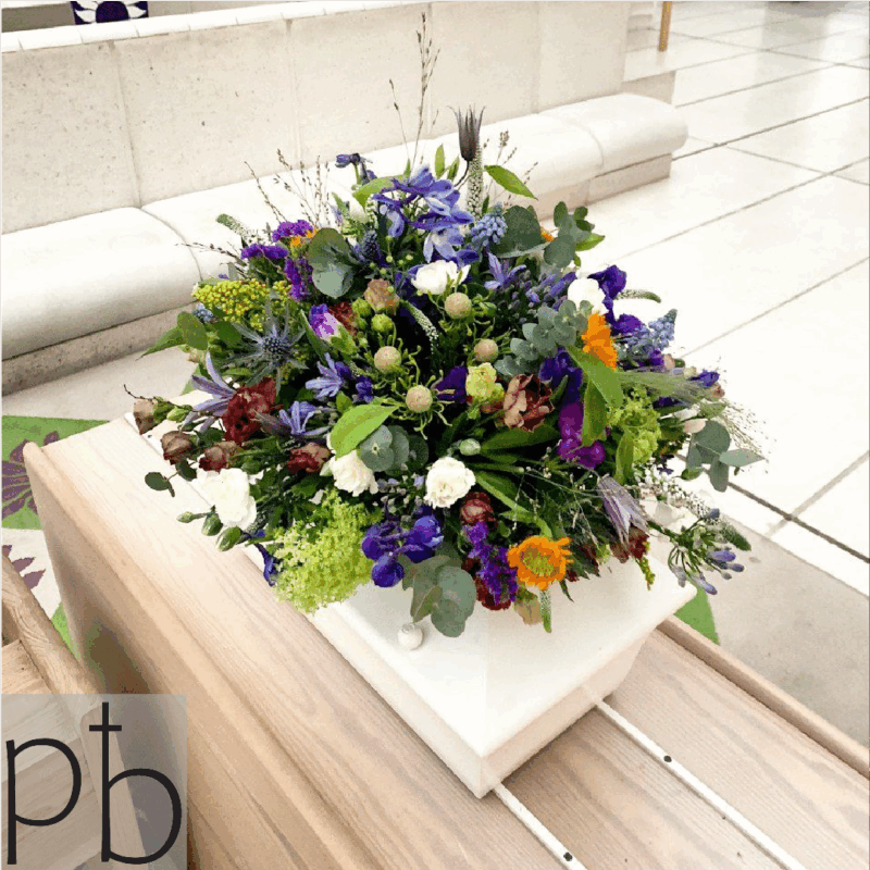 Begravelsesblomster i hvid og grøn med rolig komposition, leveret planlagt og respektfuldt til kirke eller kapel