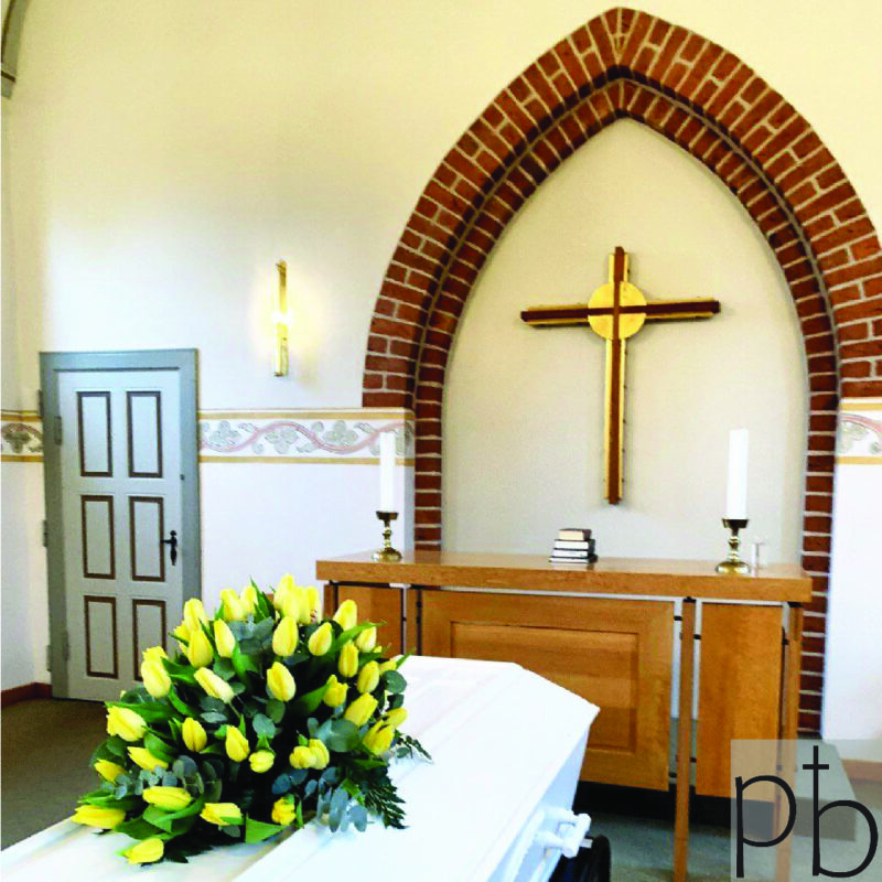 Værdig båredekoration i hvid og grøn med eucalyptus og roser, leveret planlagt til kirke i Greve