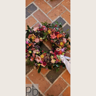 Begravelsesblomsterhandler i Albertslund – krans og bårebuket fra Paradis Blomster foran kirkedør.